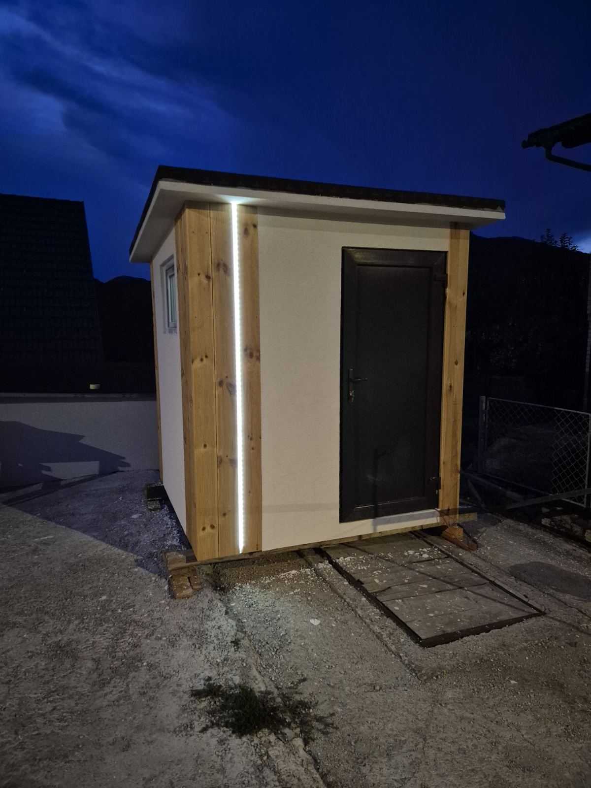 Model S zvečer, pogled na vrata in osvetljeno leseno oblogo